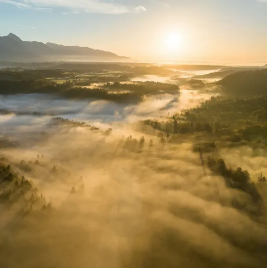 Sunrise over a peaceful valley with morning mist and mountains