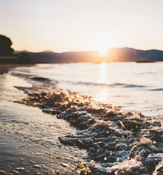 kevin-oetiker-IVlofHLR9qo-unsplash (1) Sunset over a peaceful shoreline with gentle waves